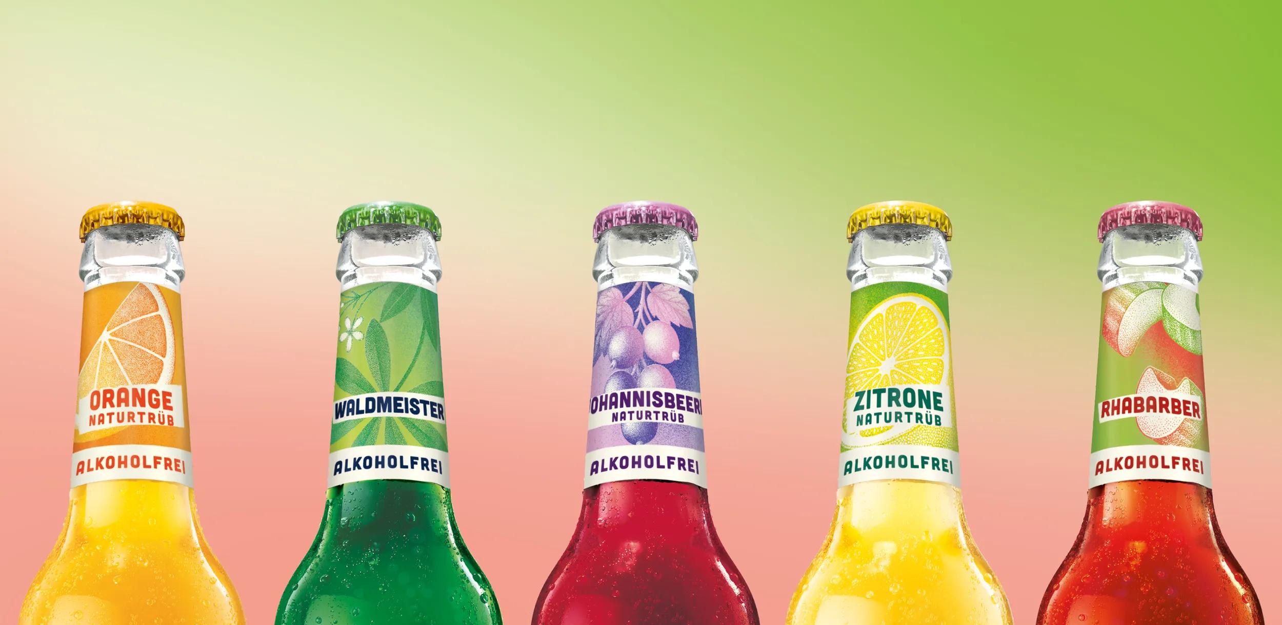5 Flaschenhälse mit bunten Etiketten sind vor einem grün-rotem Hintergrund zu sehen.