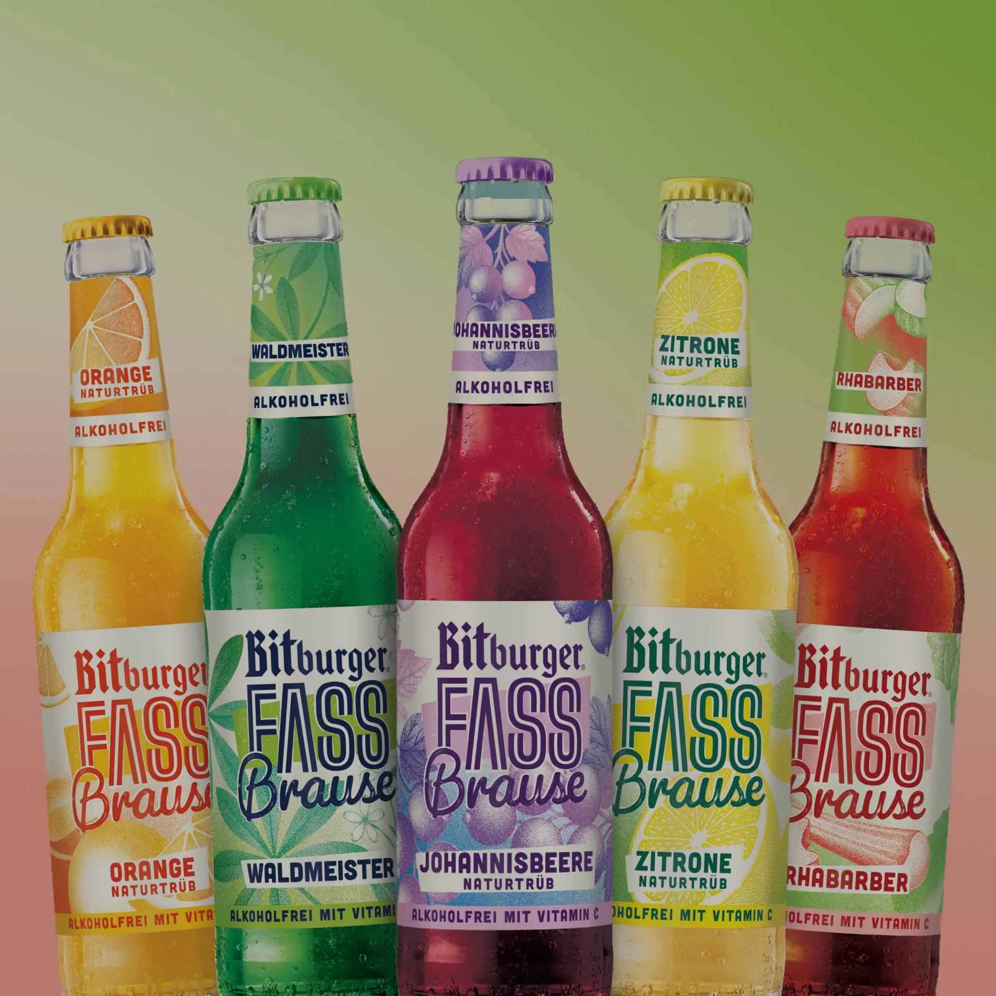 5 flaschen mit unterschiedlichen bunten Etiketten, vor einem Hintergrund mit grün-rotem Übergang.