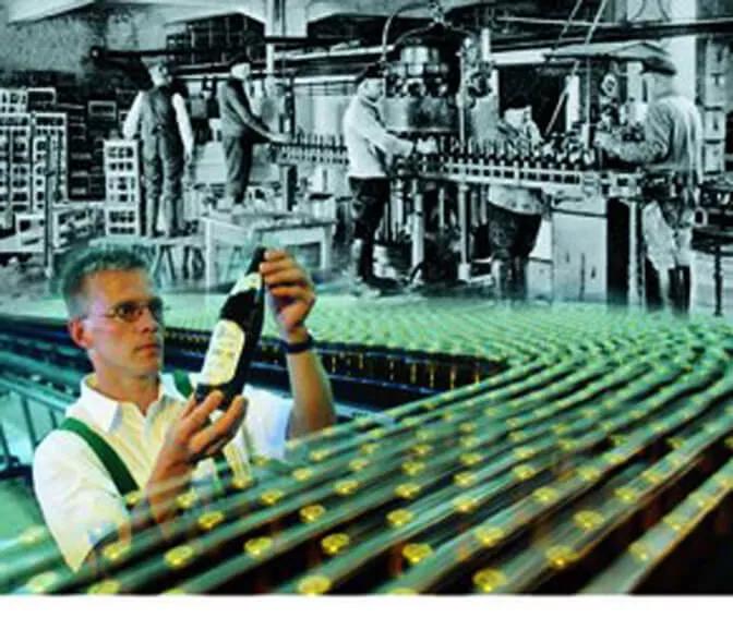 Ein Foto aus der Qualitätskontrolle der Bitburger Brauereigruppe indem ein Mitarbeiter eine Flasche inspiziert.