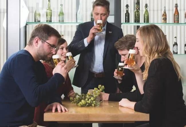 Fünf Personen an einem Tisch riechen jeweils an ihren Bieren.