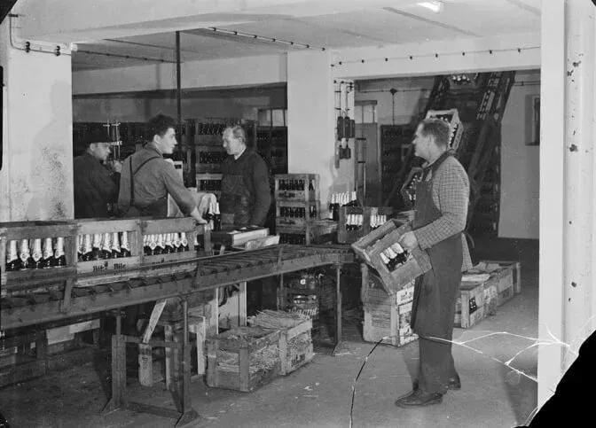 Ein Foto von Mitarbeiter:innen eine Staniolierung per Hand vornehmen.