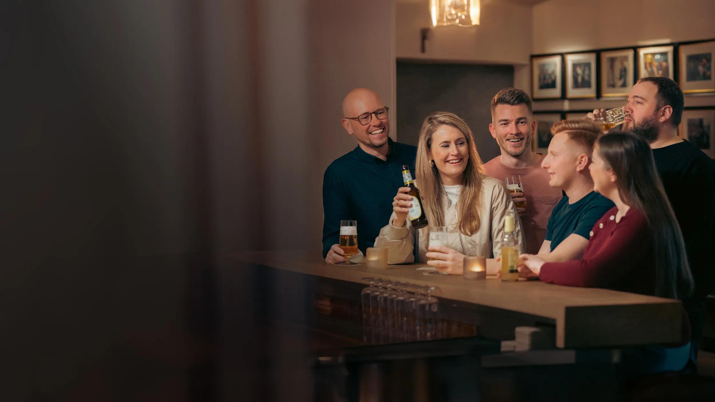 Eine Gruppe sitzt an einer Bar und trinken Bier 